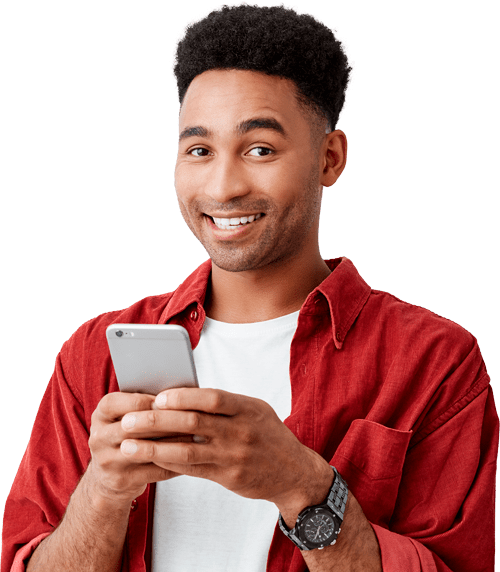 A black man smiling while using his smart phone.
