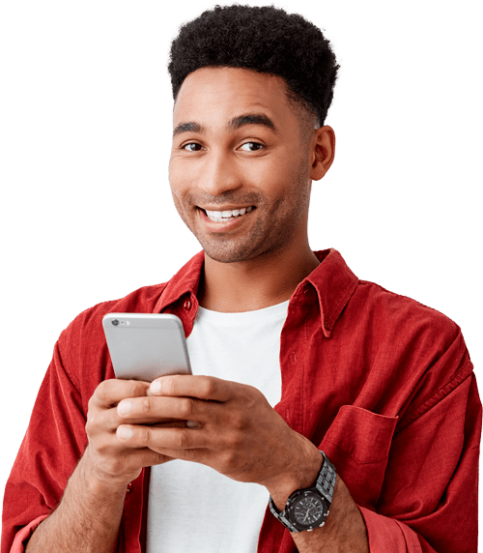 A black man smiling while using his smart phone.
