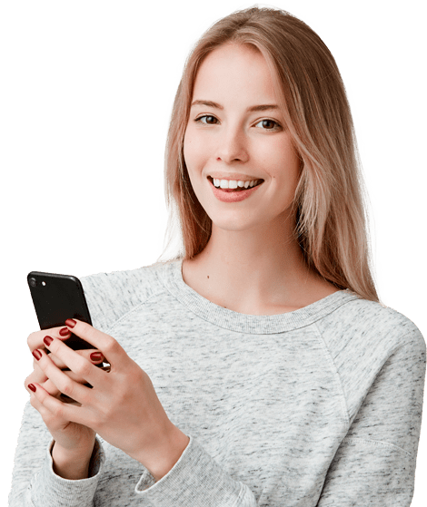 A young woman smiling while holding a cell phone.